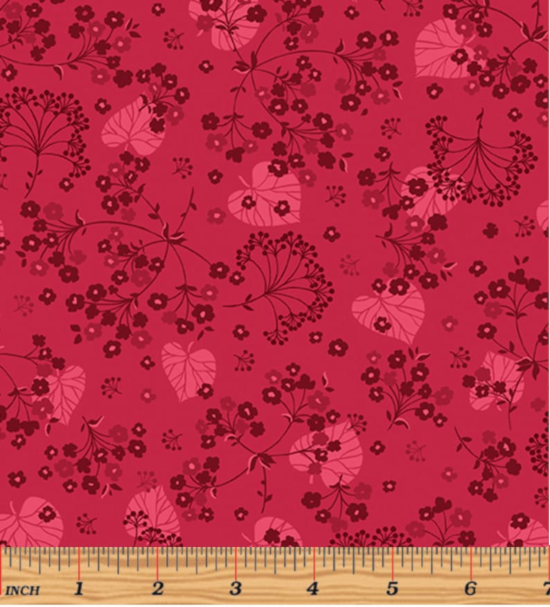 K&ouml;nnte beinhalten: Ein roter Stoff mit einem sich wiederholenden Muster aus rosa Bl&auml;ttern und dunkelroten Bl&uuml;ten. Der Stoff hat ein Lineal mit Zollmarkierungen.