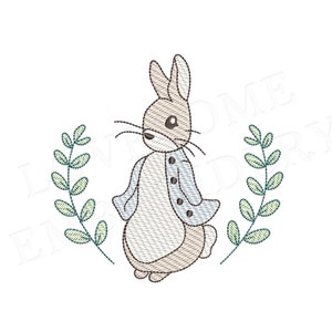 May include: An embroidery design featuring a brown rabbit wearing a light blue jacket with dark buttons, positioned between two vertical green leafy branches. The rabbit has long ears, whiskers, and a white belly, rendered in a stitched style.