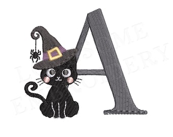 Puede incluir: Un gato negro con un sombrero de bruja morado y amarillo con una araña colgando de él se sienta frente a la letra A. La letra es gris y tiene un aspecto cosido.