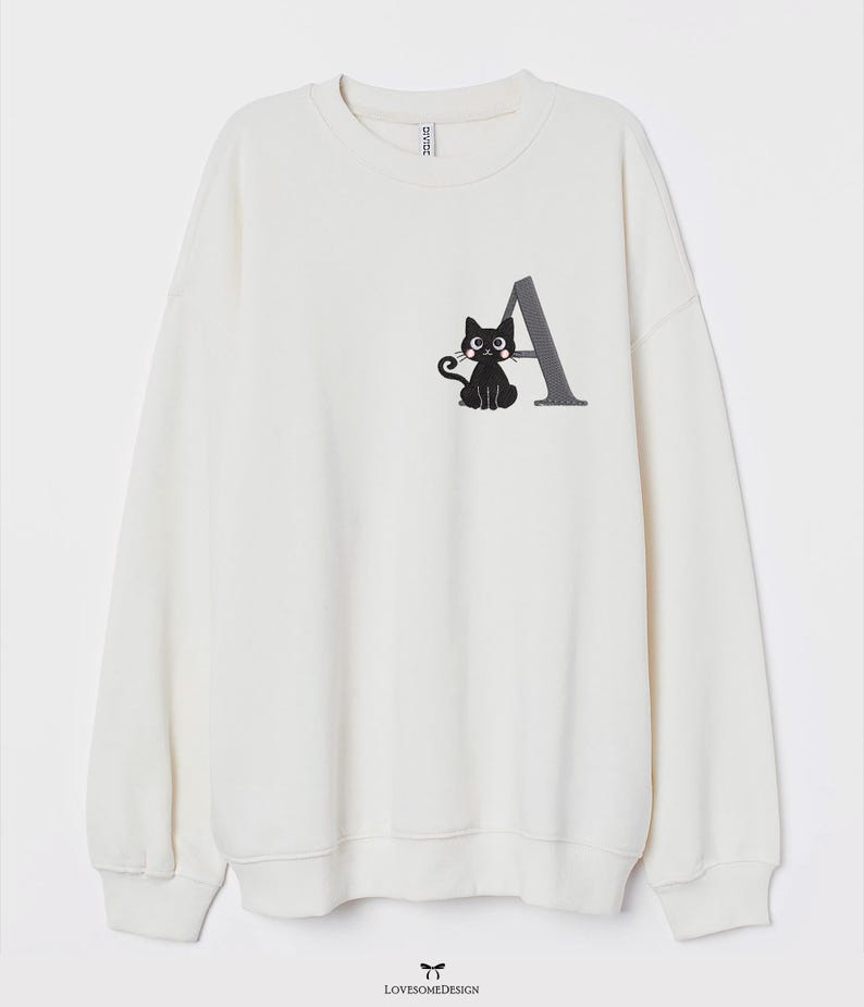 May include: White sweatshirt with a black cat and the letter A embroidered on the front.