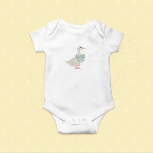 May include: White baby onesie with a light brown embroidered goose wearing a blue bow.