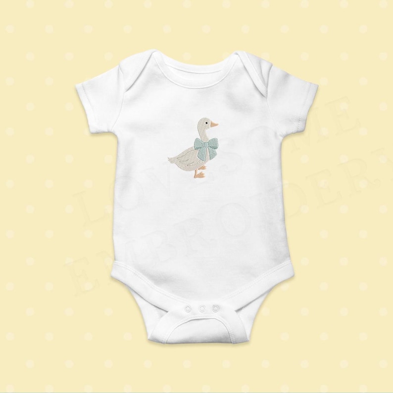 May include: White baby onesie with a light brown embroidered goose wearing a blue bow.