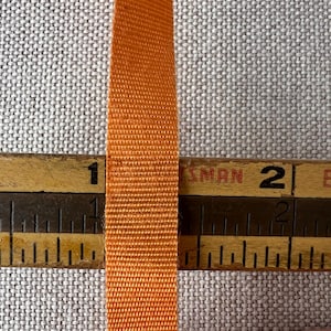 By the spool.  orange rayon ribbon