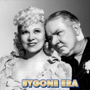 May include: Black and white photo of a woman with blonde curly hair and a man with a serious expression. The woman is wearing a lacy blouse and the man is wearing a suit. The text "BYGONE ERA" is at the bottom of the image.