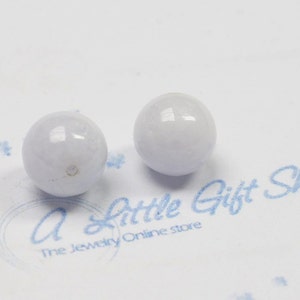 May include: Two smooth, round, light blue beads. The beads are about 1 inch in diameter.