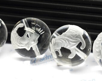 May include: Four clear glass beads with white etched designs of animals. The beads are round and have a smooth, polished surface.