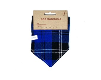 Peut inclure: Bandana pour chien en tissu écossais bleu et noir avec des accents blancs. La bandana porte une étiquette indiquant "DOG BANDANA" et "THE ECO DOG DESIGN COMPANY".
