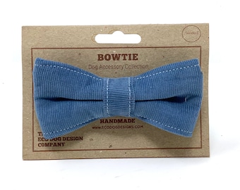 May include: A blue corduroy bow tie for dogs. The bow tie is handmade and comes on a card with the text "BOWTIE Dog Accessory Collection HANDMADE www.ECODOGDESIGNS.COM THE ECO DOG DESIGN COMPANY"