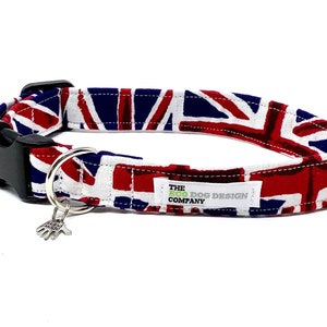 Op de afbeelding: Een rood, wit en blauwe hondenriem met een Union Jack-patroon. De riem heeft een zwarte gesp en een zilveren hanger met een pootprint. De riem is gelabeld "THE ECO DOG DESIGN COMPANY."