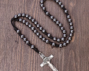 May include: A black beaded rosary necklace with a silver crucifix pendant. The crucifix features a depiction of Jesus Christ.