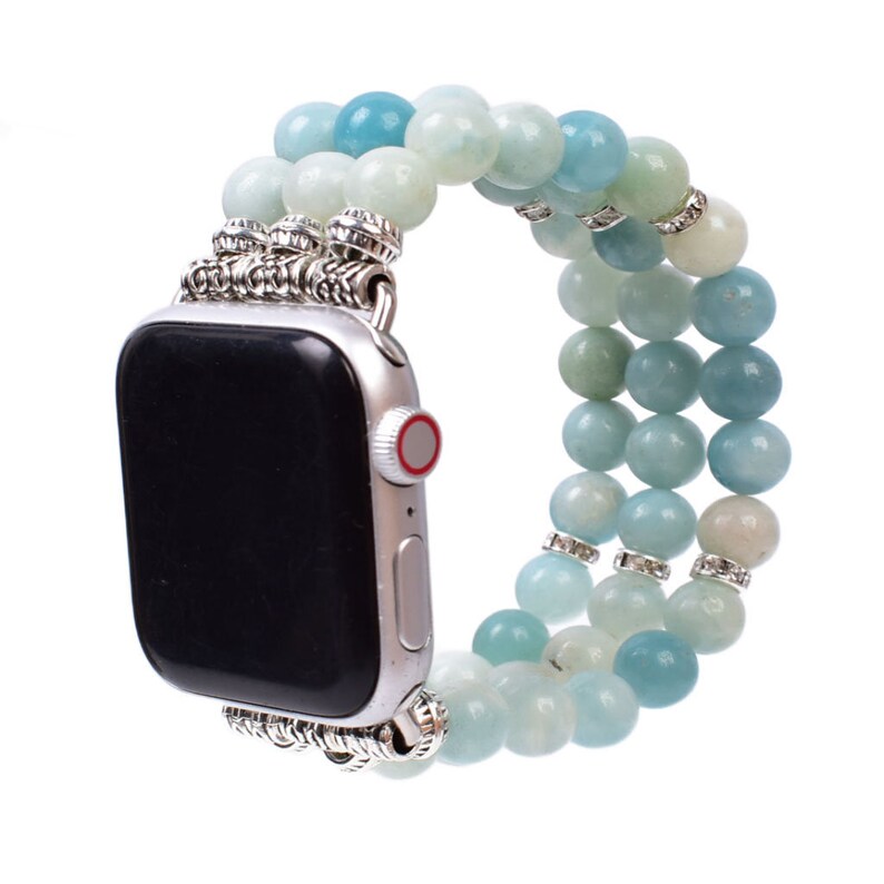 May include: A light blue and white beaded Apple Watch band with silver accents. The band is made of multiple strands of beads and has a metal clasp.
