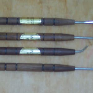 May include: Four wooden-handled tools with metal tips. The tools are labeled A, B, C, and Z. The tools have a gold-colored band around the handle.