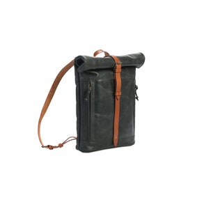 May include: A dark blue leather backpack with a roll-top closure and brown leather straps.