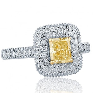 May include: A square-shaped engagement ring with a yellow diamond center stone surrounded by a double halo of smaller diamonds. The ring band is also set with smaller diamonds.