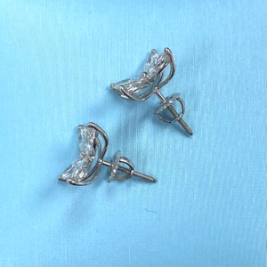 May include: A pair of silver butterfly earrings with clear crystal accents. The earrings have a screw-back closure.