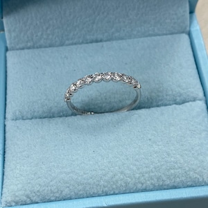 Pu&ograve; includere: Una fascia d'argento con una fila di piccoli diamanti rotondi incastonati in una montatura a bezel.