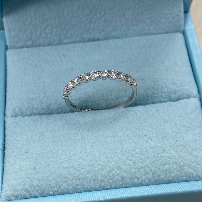 Pu&ograve; includere: Una fascia d'argento con una fila di piccoli diamanti rotondi incastonati in una montatura a bezel.