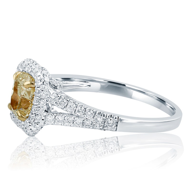 May include: A white gold engagement ring with a yellow diamond center stone surrounded by a halo of smaller diamonds. The band is split and features a row of diamonds on each side.