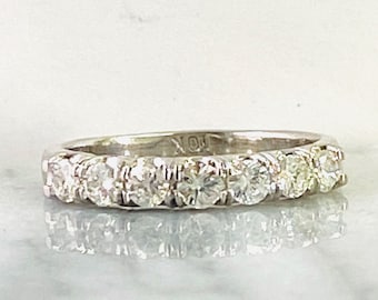 May include: A silver band with a row of small, round, clear diamonds.