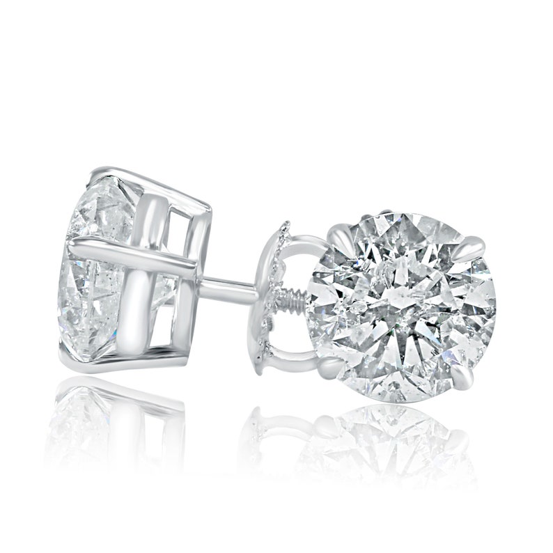 May include: A pair of silver stud earrings with a large round diamond in each earring.