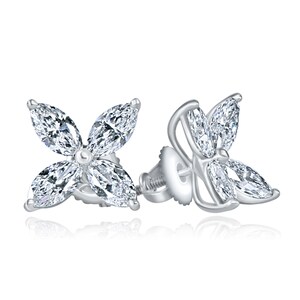 May include: A pair of silver earrings with a four-leaf clover design featuring marquise-shaped diamonds.
