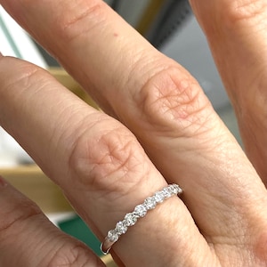 Pu&ograve; includere: Una delicata fascia d'argento con una fila di piccole pietre preziose rotonde e chiare incastonate in pav&eacute;.