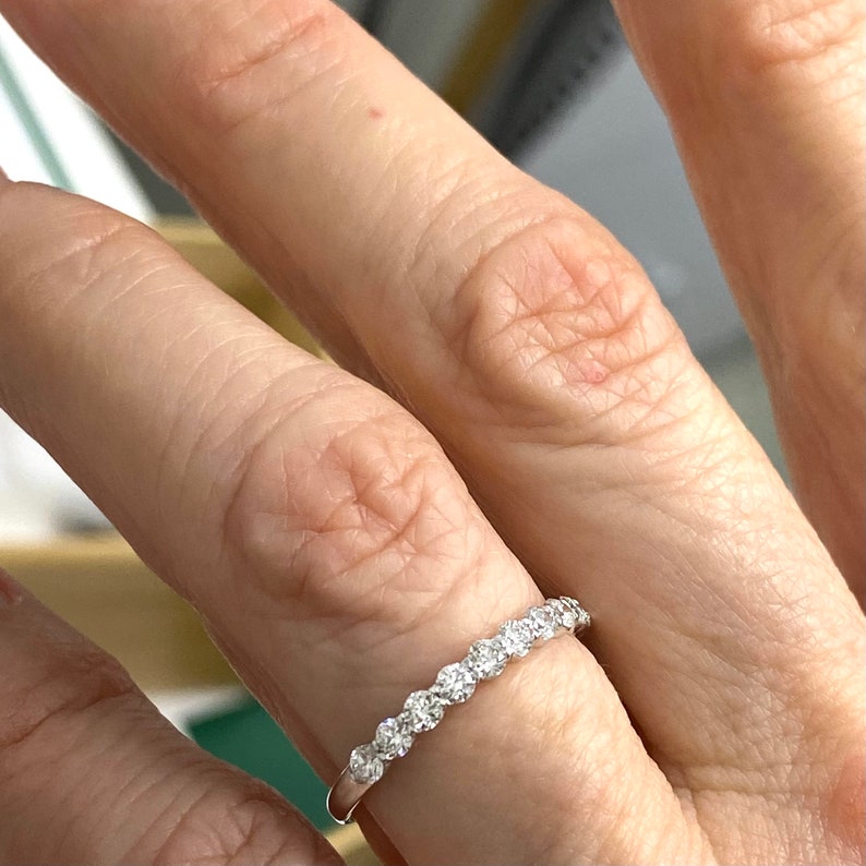 Pu&ograve; includere: Una delicata fascia d'argento con una fila di piccole pietre preziose rotonde e chiare incastonate in pav&eacute;.