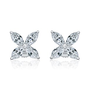 May include: A pair of silver earrings with a flower design made of clear marquise-shaped stones.