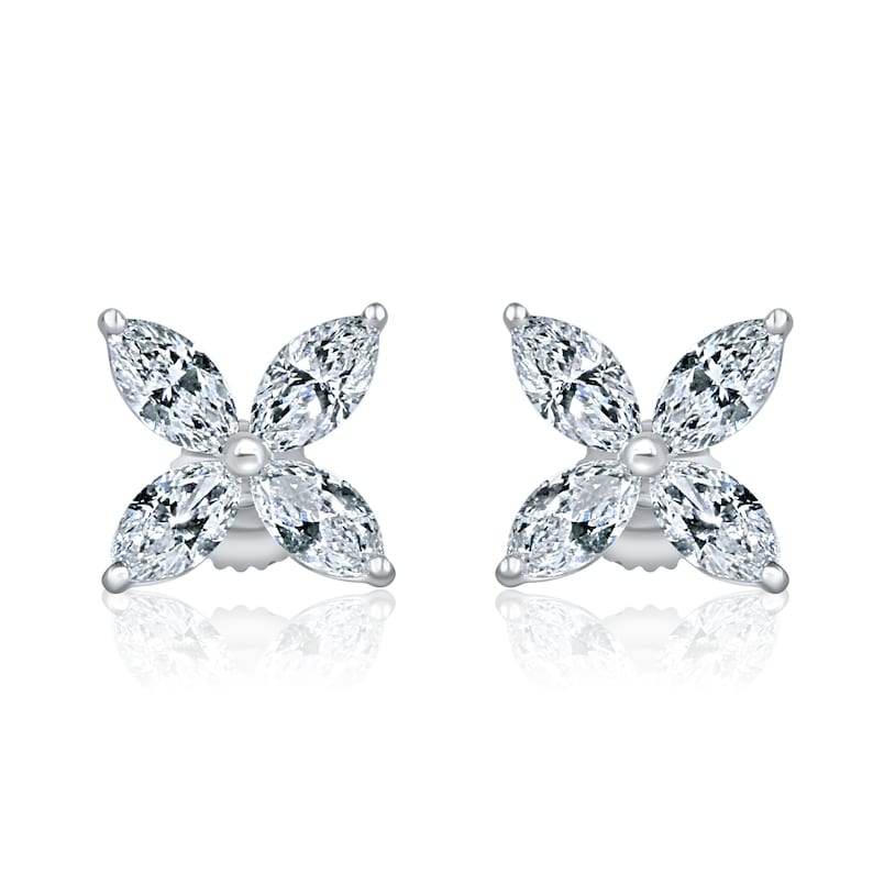 May include: A pair of silver earrings with a flower design made of clear marquise-shaped stones.
