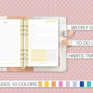 Op de afbeelding: Een witte planner met gouden ringen en een roze achtergrond met witte stippen. De planner heeft een sectie voor notities, wekelijkse doelen, een to-do-lijst en een gewoontetracker. De planner is verkrijgbaar in 10 kleuren.