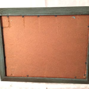 May include: A teal wood picture frame with a brown cardboard backing.