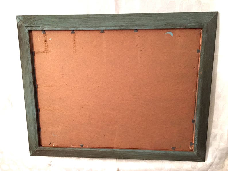 May include: A teal wood picture frame with a brown cardboard backing.