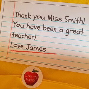 May include: A yellow card with lined paper and the text "Thank you Miss Smith! You have been a great teacher! Love James". A red apple sticker with the text "Thank you teacher" is on the bottom right corner of the card.