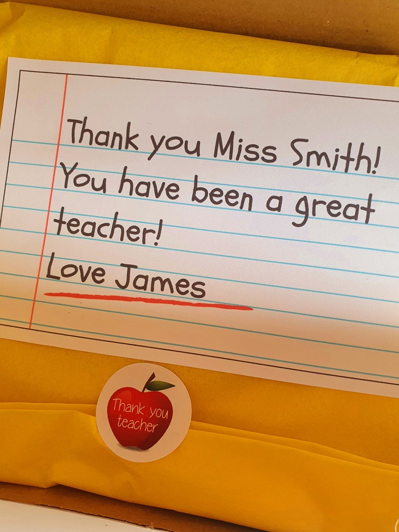 May include: A yellow card with lined paper and the text "Thank you Miss Smith! You have been a great teacher! Love James". A red apple sticker with the text "Thank you teacher" is on the bottom right corner of the card.