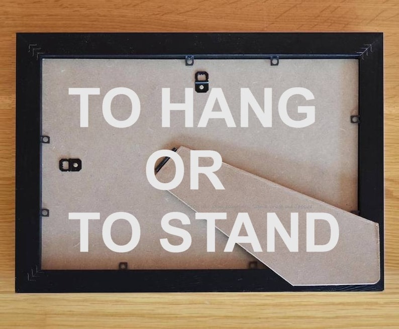 May include: Black picture frame with a brown backing. The backing has a fold-out stand and the text "TO HANG OR TO STAND" printed in white.