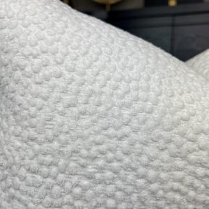 May include: White pillow with a textured, raised dot pattern.