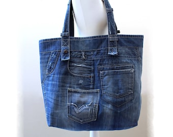 May include: A blue denim tote bag with multiple pockets and distressed details. The bag is made from recycled denim and has a unique patchwork design.