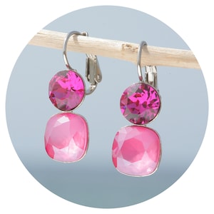 Può includere: Un paio di orecchini a clip argentati con due cristalli rosa su ogni orecchino. Il cristallo superiore è un cristallo rotondo rosa scuro. Il cristallo inferiore è un cristallo quadrato rosa chiaro.