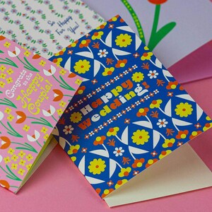 a close up of three cards on a pink surface