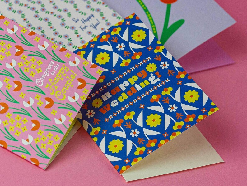 a close up of three cards on a pink surface