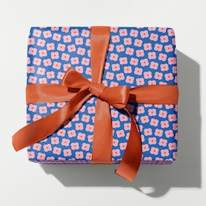 May include: A blue gift box with a pink floral pattern and a bright orange ribbon tied in a bow.