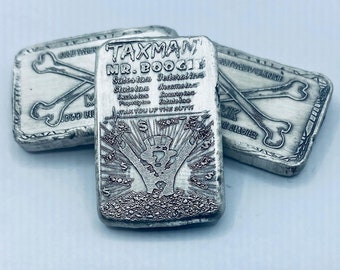 May include: Three silver bars with the text "TAXMAN MR. BOOGIE" and other text. The bars have a skull and crossbones design and the words "ONE TROY OUNCE" and "999 FINE SILVER".