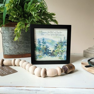 May include: A framed watercolour painting of a forest scene with the quote "Where there is a beautiful soul, there is a trail of beautiful memories." The frame is black and the painting is on a white background.