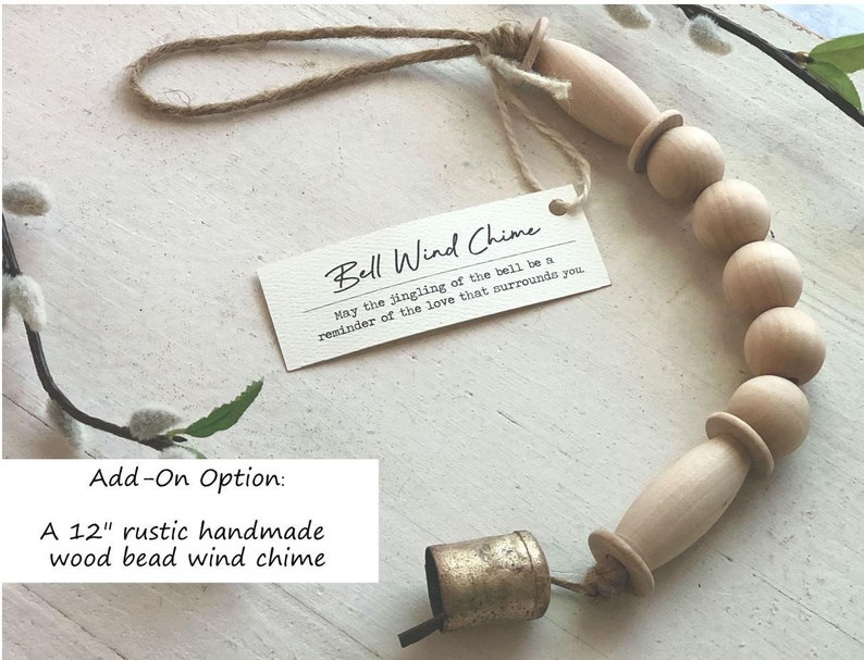 May include: A 12-inch rustic handmade wood bead wind chime with a gold bell. The chime is made of natural wood beads and has a simple, elegant design. "May the jingling of the bell be a reminder of the love that surrounds you."