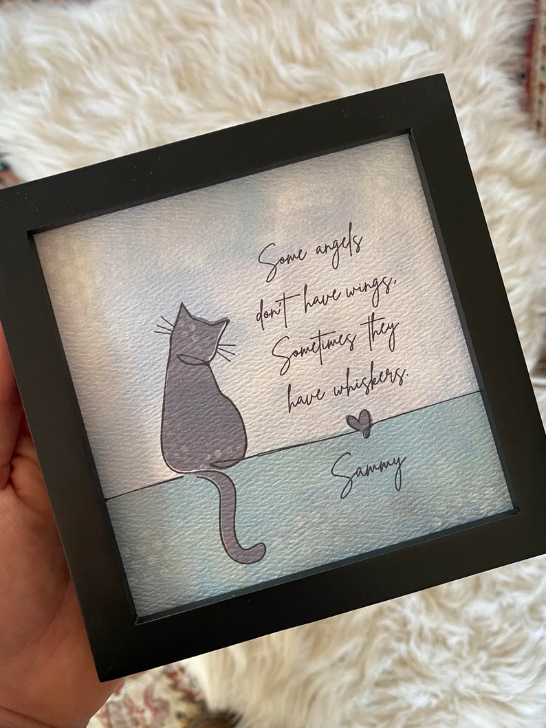 May include: A framed art print with a grey cat illustration and the text "Some angels don't have wings. Sometimes they have whiskers." A heart and the name "Sammy" are also included.