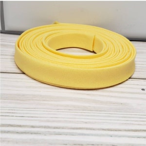 May include: A roll of yellow fabric trim, perfect for adding a pop of color to your sewing projects.