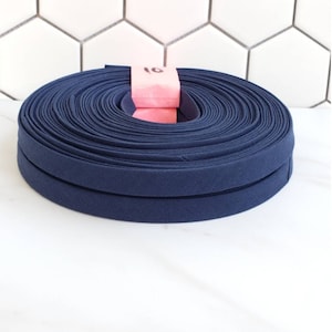 May include: A roll of 10 yards of navy blue double fold bias tape.