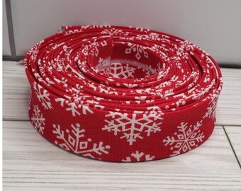 May include: A roll of red fabric with a white snowflake pattern.