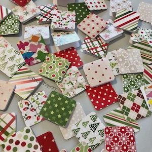 May include: A collection of small, square gift tags with various festive patterns. Designs include red and green polka dots, stripes, stars, Christmas trees, and snowflakes. The tags are in shades of red, green, white, and beige.