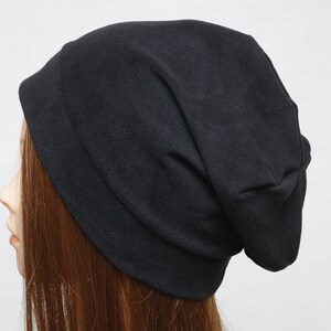 May include: A black slouchy beanie hat made of soft fleece fabric.